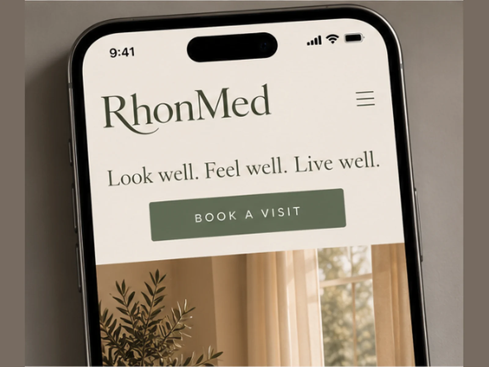 A phone open to RhonMed, with Look well. Feel well. Live well. and a button to book a visit